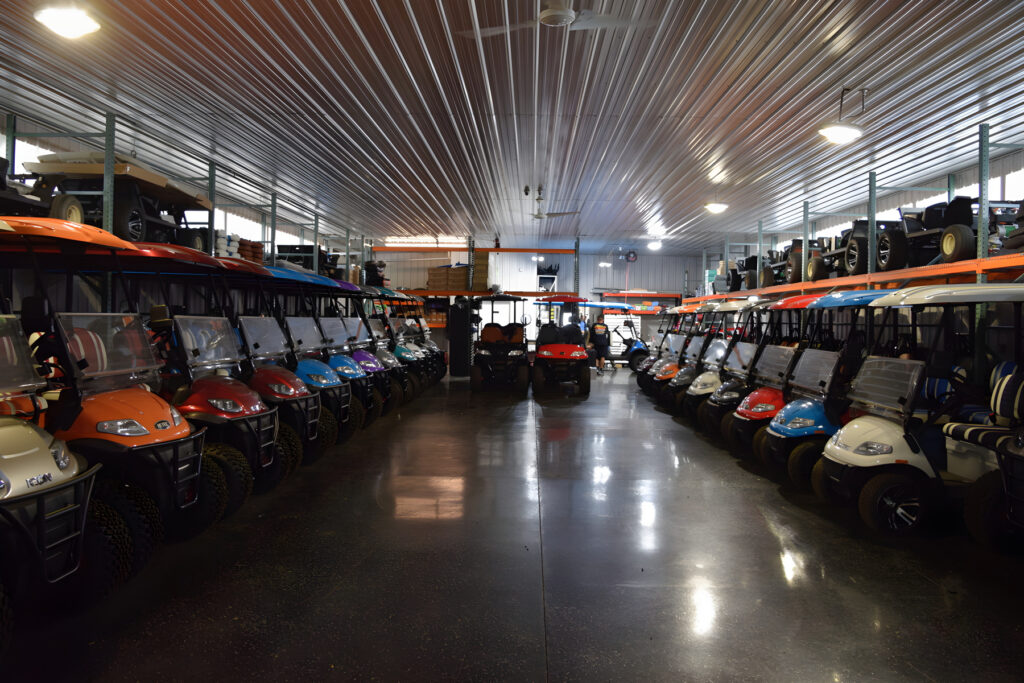 Rows of golf carts and LSVs stored indoors at Mike's Golf Carts